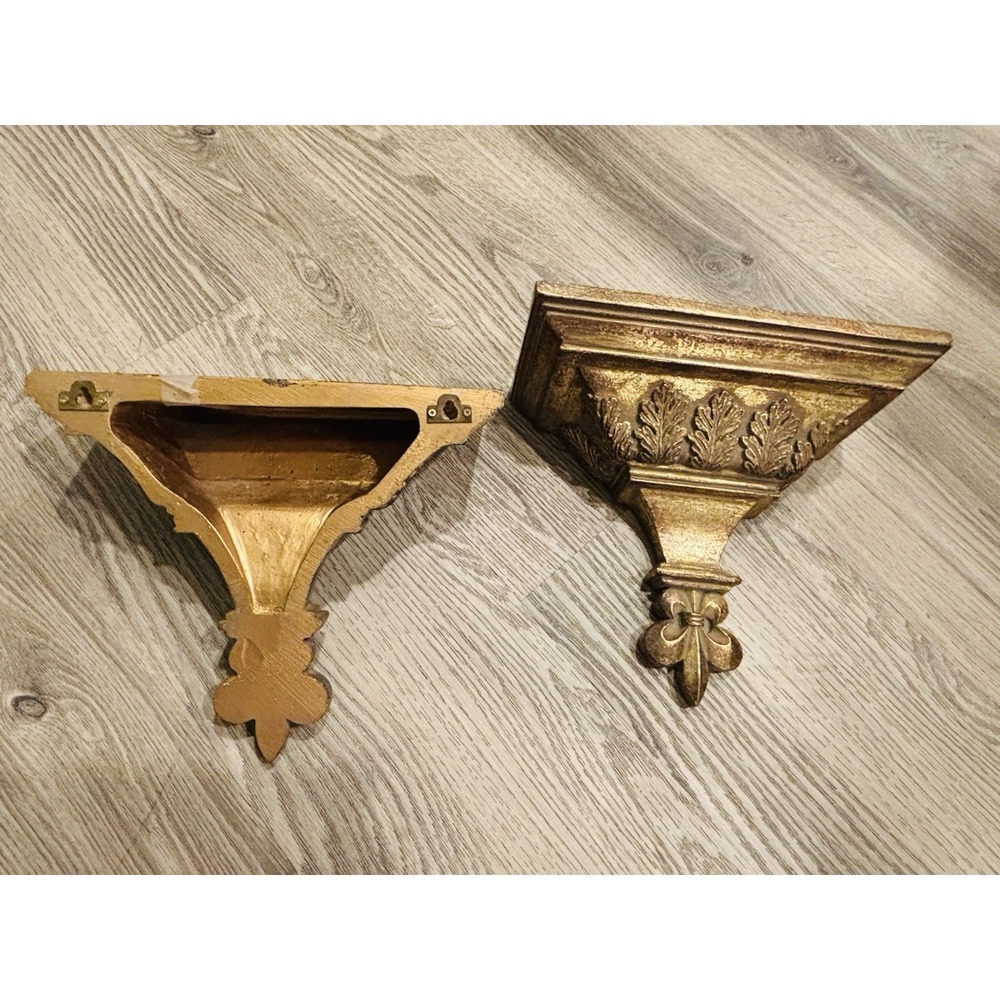 Vintage gold-toned decorative wall shelves with floral motifs.